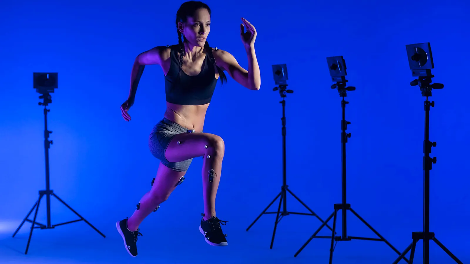 An athlete sprinting, surrounded by motion-analysis cameras